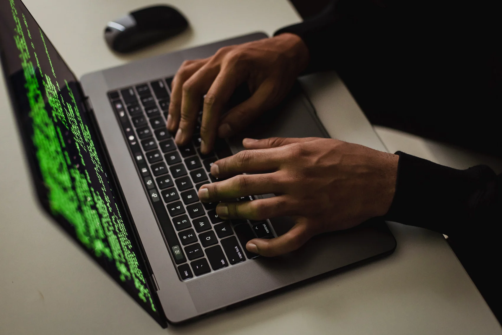 Hands working on a laptop with code on screen
