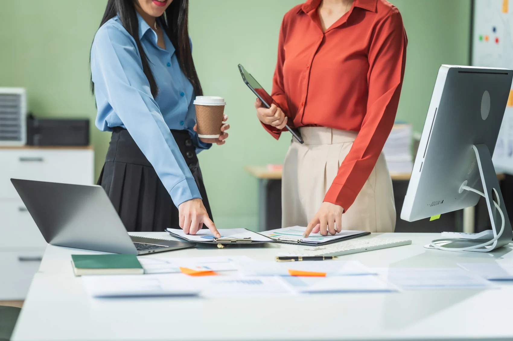 Two colleagues reviewing business information at a workstation