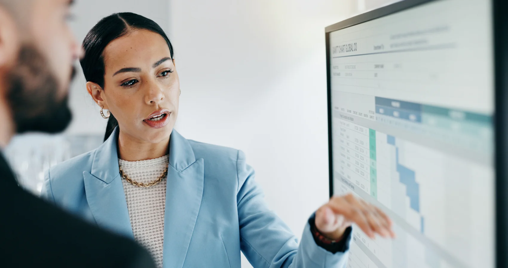 Business professionals discussing information on a screen